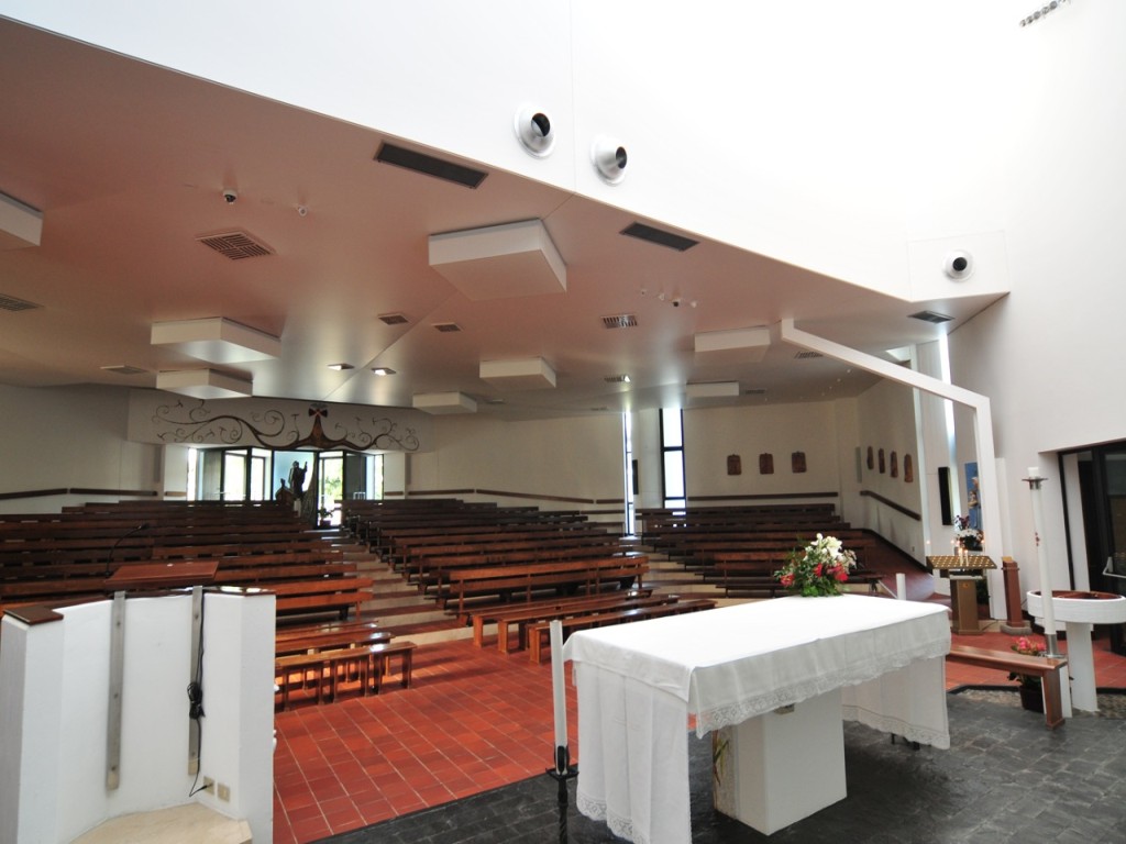 Vista della chiesa dall’altare verso i banchi, con controsoffitto e terminali dell’aria