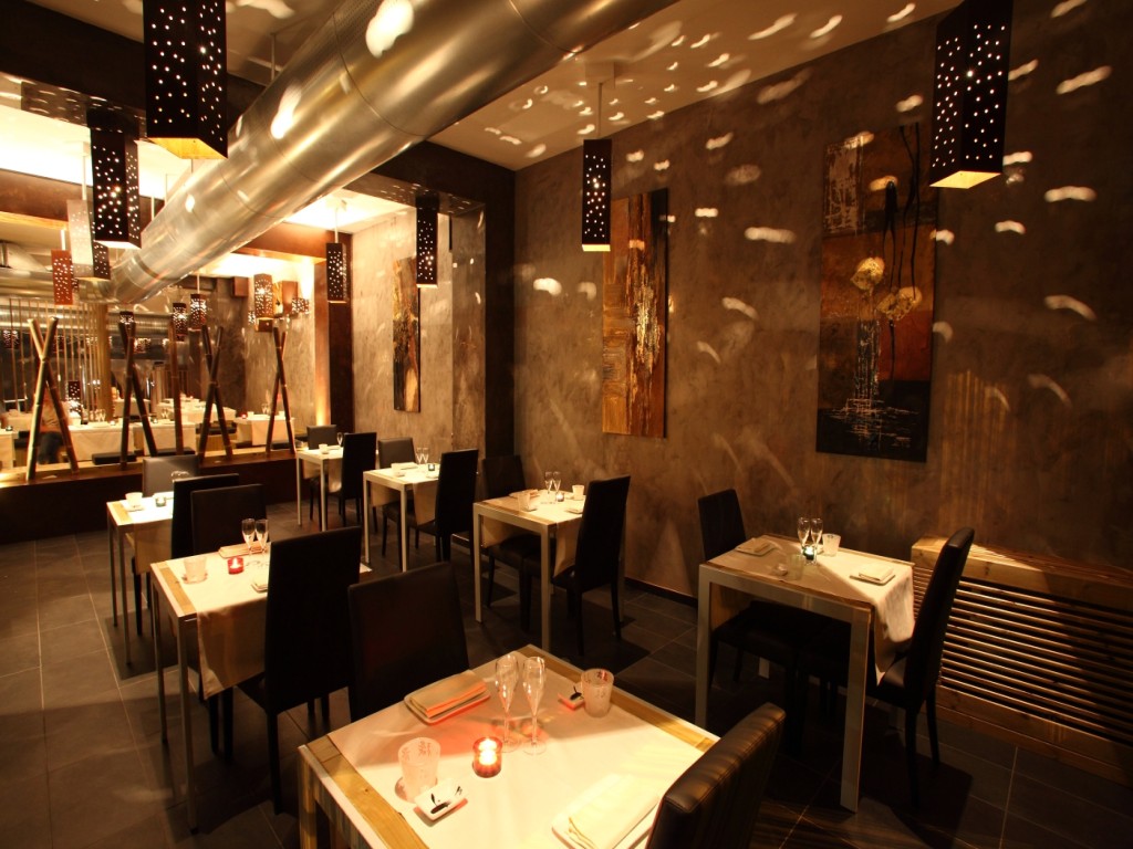 Canalizzazione a vista lungo una sala del Megumi con tavoli e illuminazione decorativa