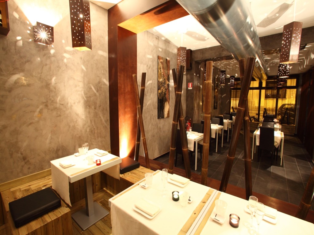 Canale in acciaio che attraversa il ristorante sopra gli arredi in legno