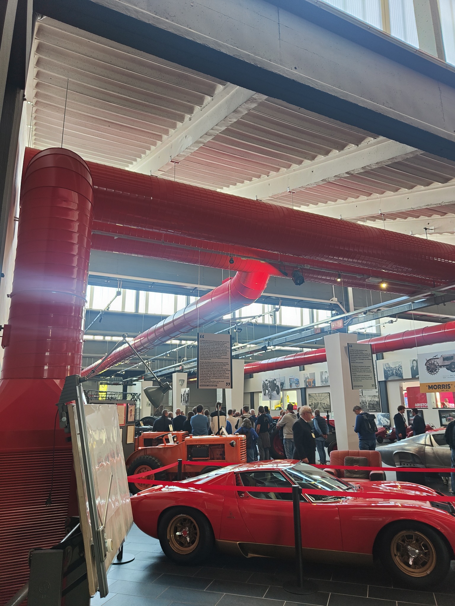 Canali rossi a vista sopra le automobili e i mezzi esposti nel Museo Ferruccio Lamborghini