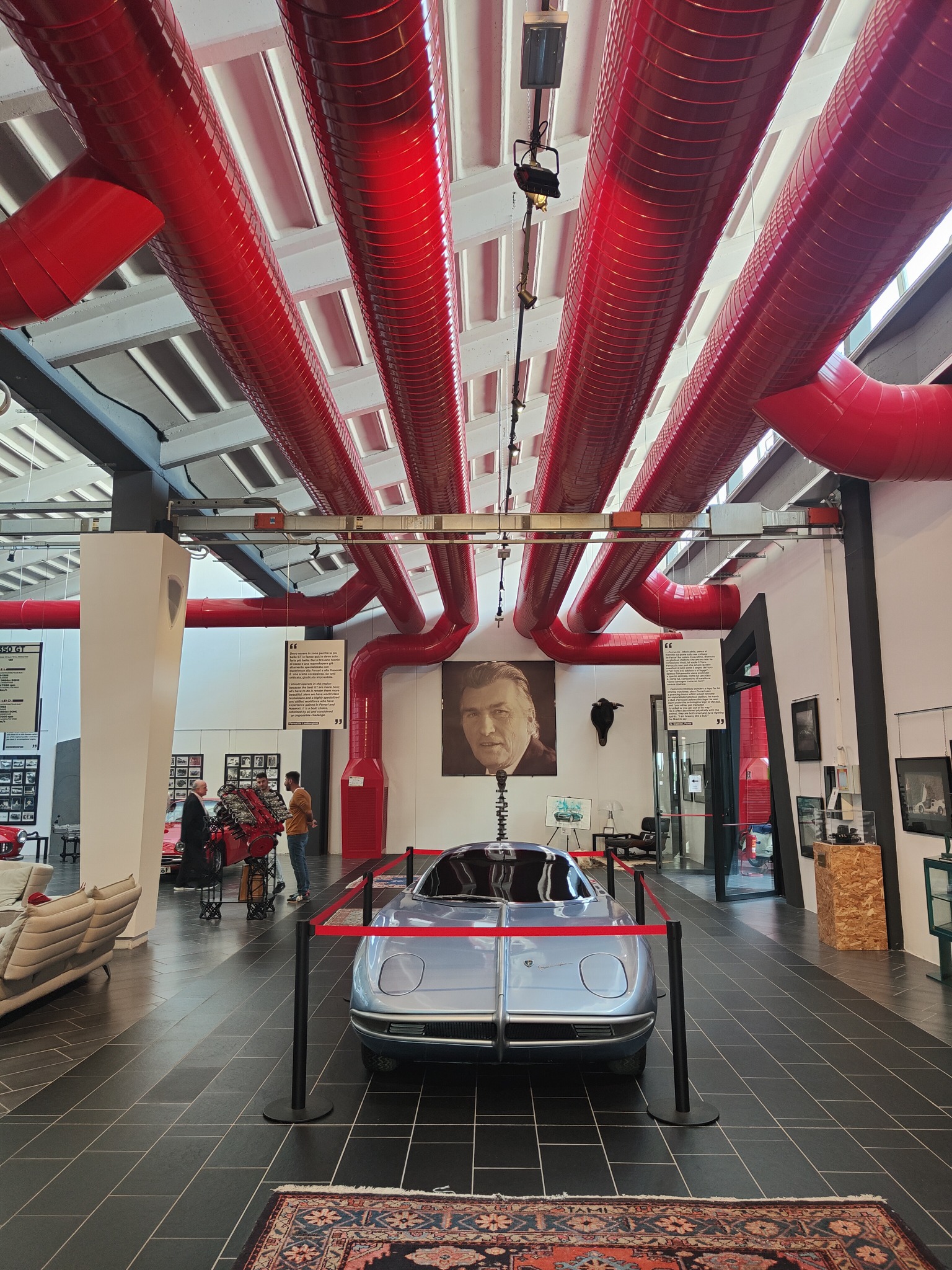 Museo Ferruccio Lamborghini: canalizzazioni rosse a vista sopra un’automobile esposta
